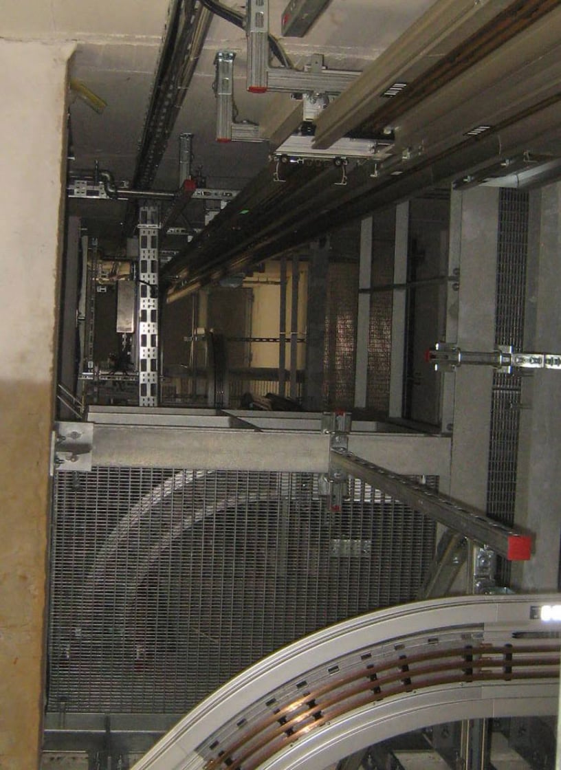 Das komplette Schienensystem wurde nach statischem Erfordernis in regelmäßigen Abständen an den Gebäudewänden befestigt. Die Übertragung von Körperschall und Schwingungen der Anlage in das Gebäude wurden durch Entkopplung der Anlage minimiert.